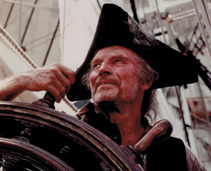 Long John Silver at the wheel of the Hispaniola (HMS Bounty)