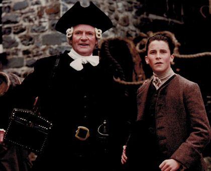 Julian Glover as “Dr. Livesy” and Christian Bale as “Jim”