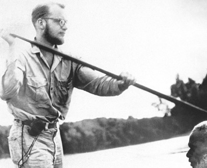 Michael Rockefeller poling a dugout canoe.